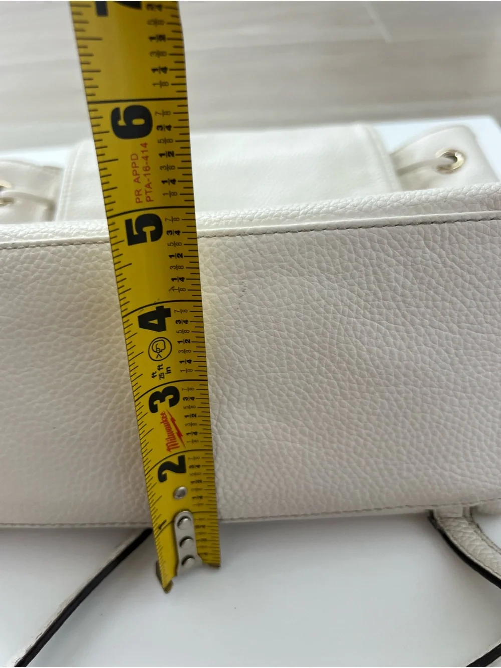 Kate Spade New York creamy white leather drawstring flap backpack